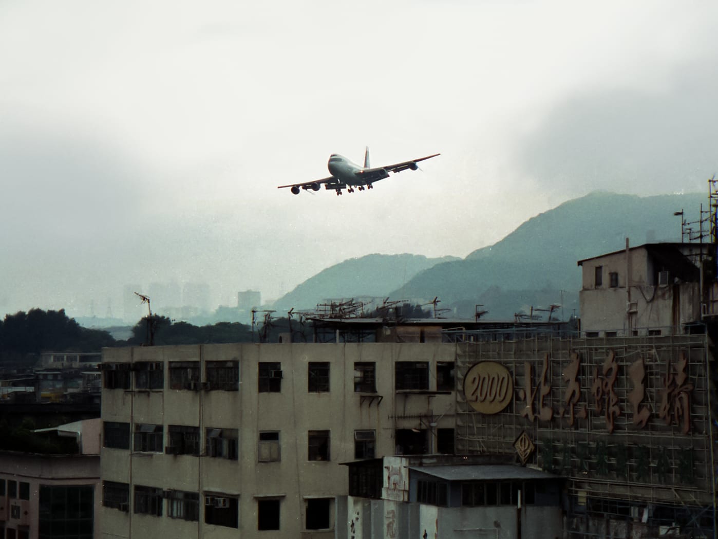 A Boeing 747 on final approach over Kowloon rooftops into Kai Tak